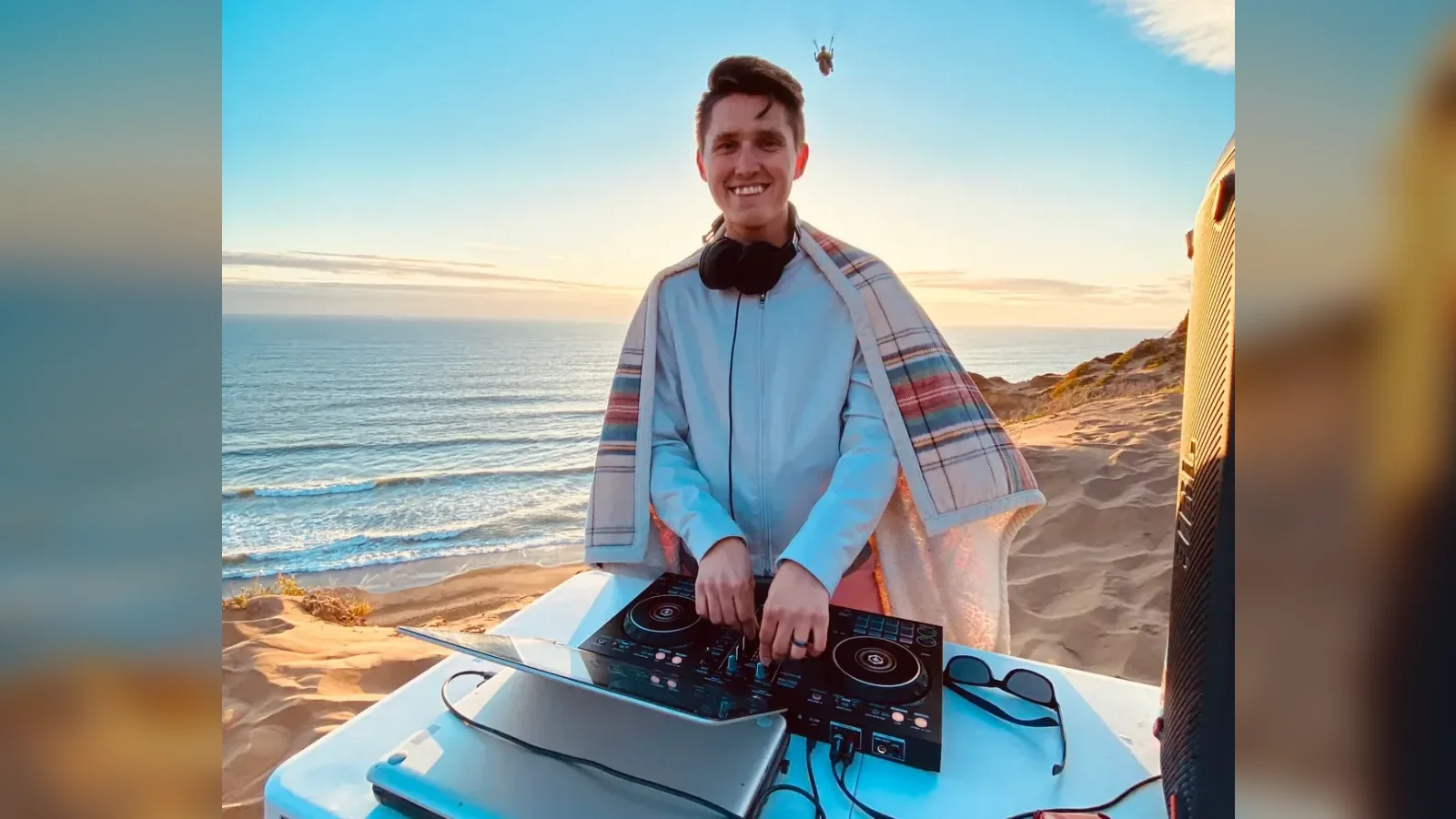 Oleksandr DJing with his controller and laptop by the ocean at the first Sunset Beats in Pacifica